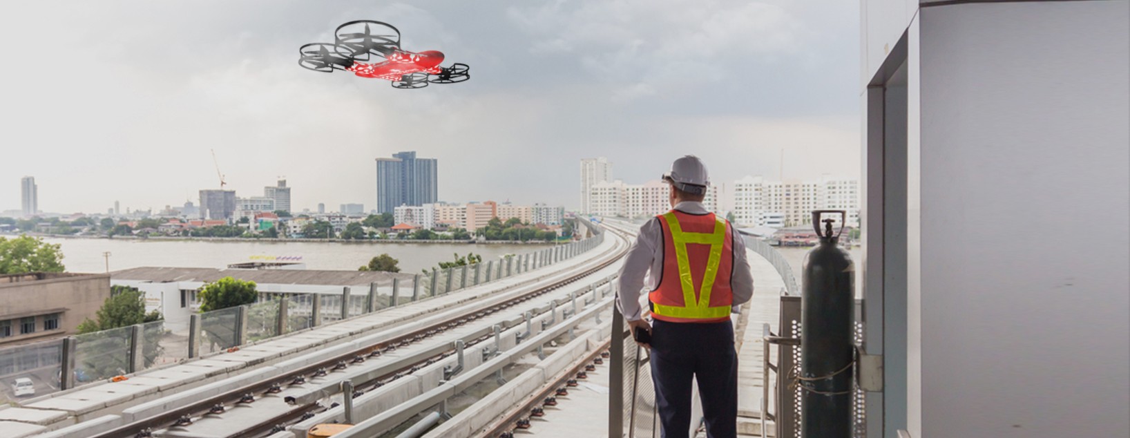 Technician operating a drone over railway tracks for smart UAV inspection